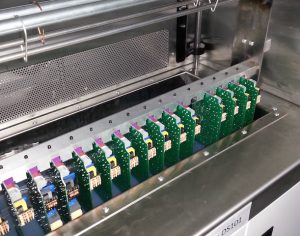 Printed circuit boards (PCBs) being dipped into conformal coating using a DS101 dip system