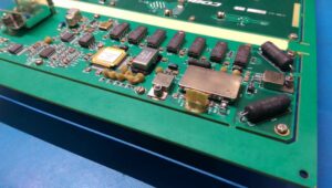 Close-up of PCB with liquid latex masking and hybrid barrier sealing applied to protect connectors and edges during conformal coating.