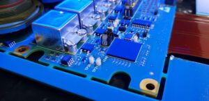 PCB spray coated with conformal coating showing an even protective film on components