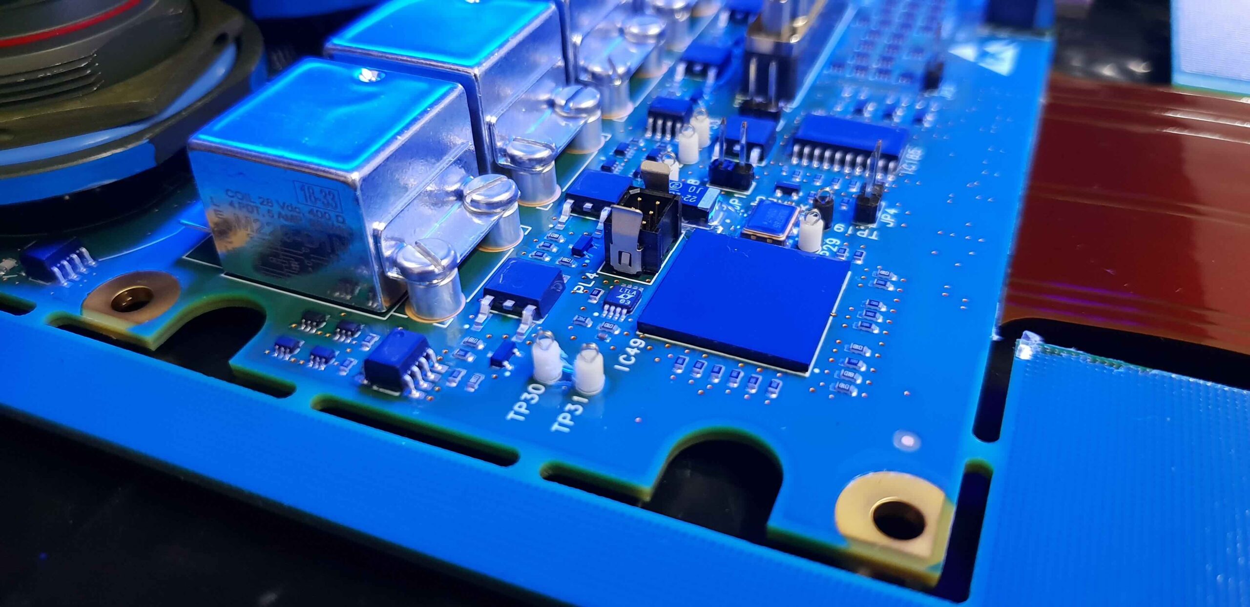 PCB spray coated with conformal coating showing an even protective film on components