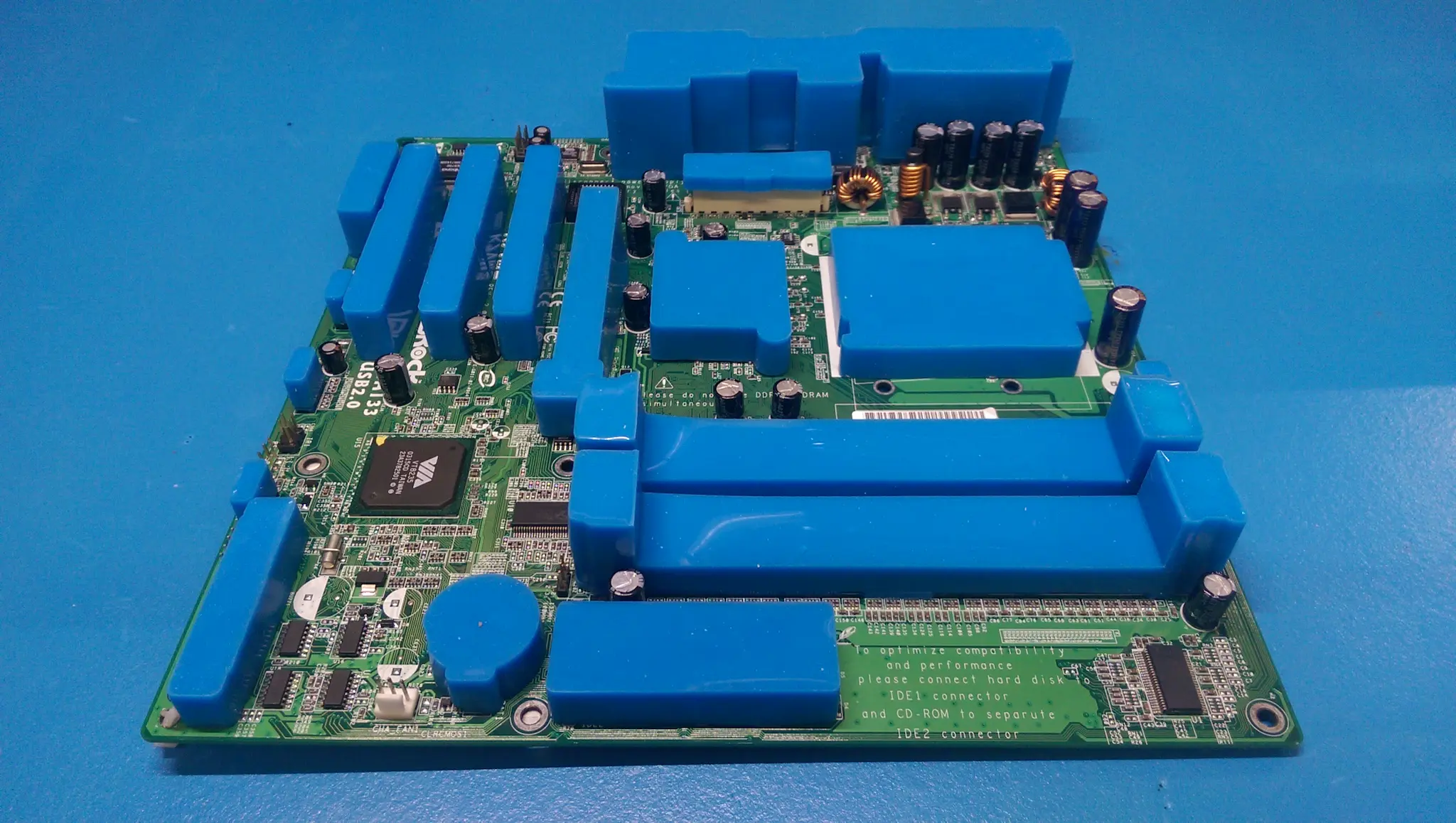 PCB fitted with reusable silicone masking boots protecting connectors, components and keep-out areas during conformal coating.